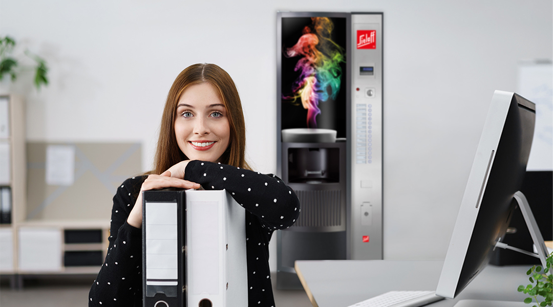 Eine Frau im Büro vor einem Automaten