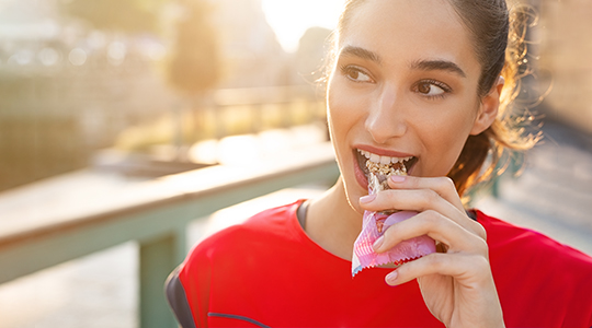 Eine Frau die einen Riegel isst