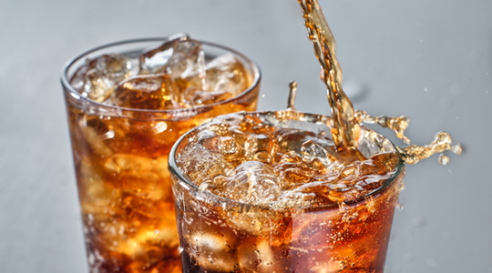 Zwei Gläser mit Eiswürfeln und einem Softdrink