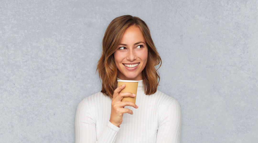 Eine Frau mit einem Kaffeebecher in der Hand