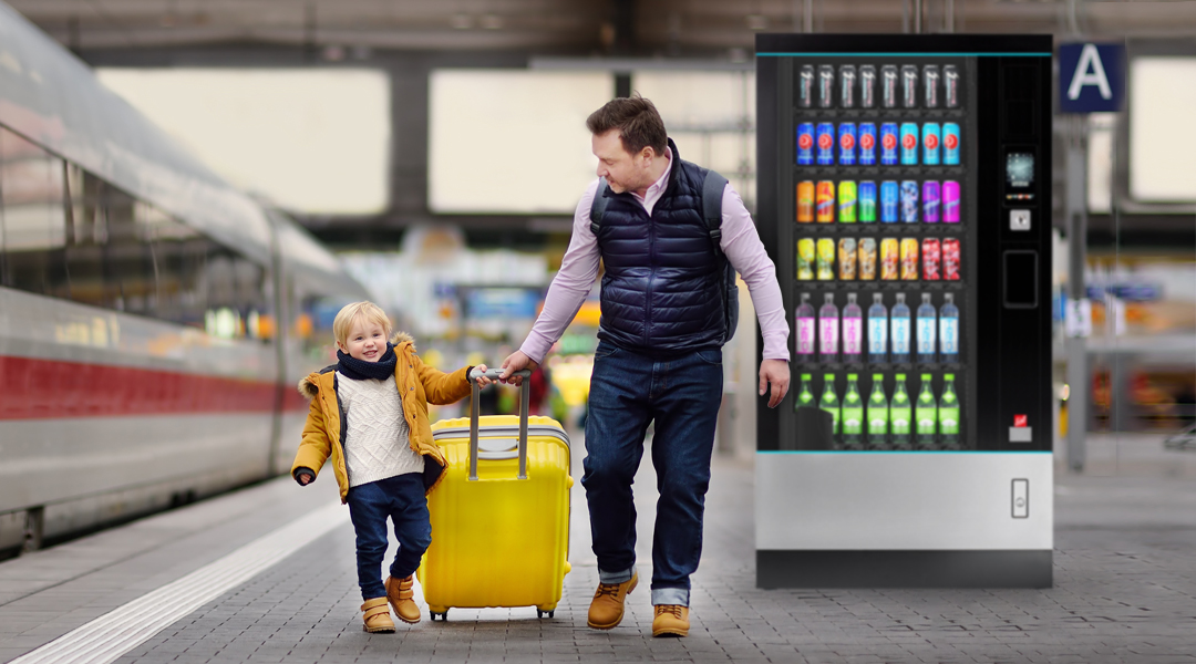 Ein Mann und ein Kind neben einem Automaten am Bahnhof