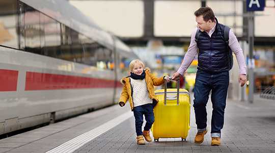 Ein Mann und ein Kind auf einem Bahnhof