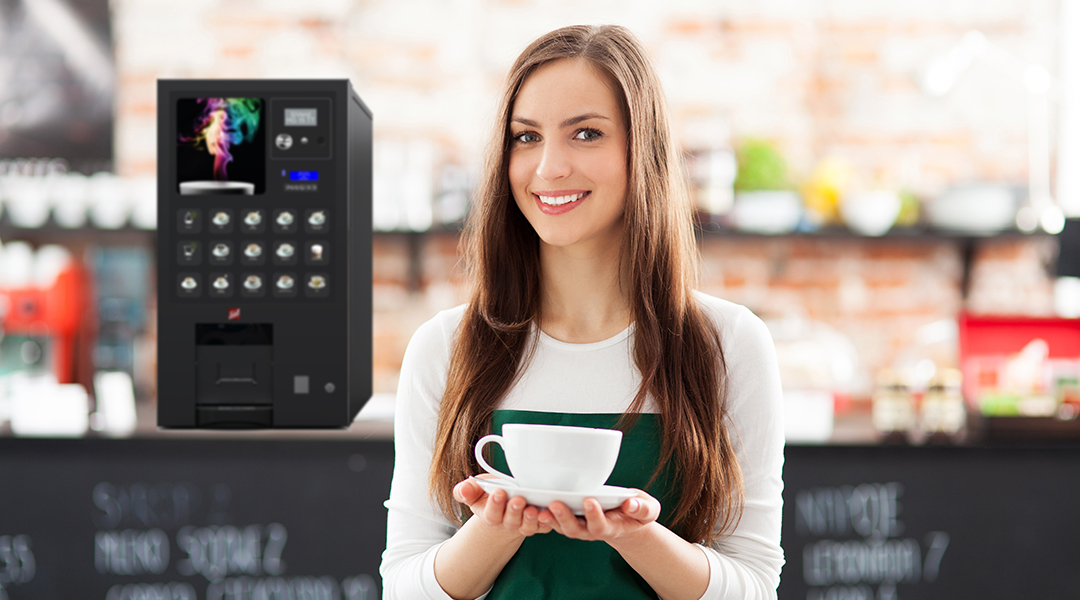 Eine Frau mit einer Kaffeetasse vor einem Automaten
