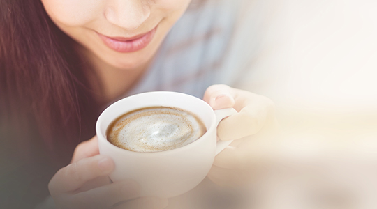 Eine Frau mit einer Kaffetasse in ihren Händen