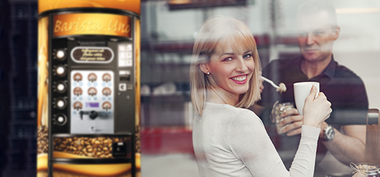 Ein Bild von Zwei trinkenden Menschen neben einer Espressomaschine