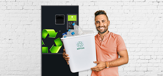 Ein Mann mit Plastikflaschen vor einem RVM Automaten